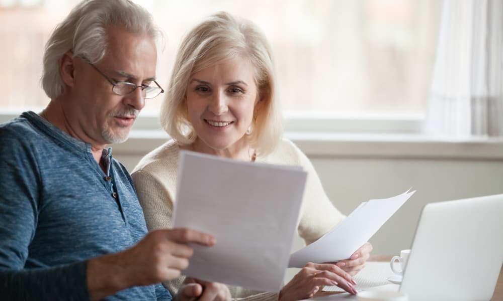An older couple looking through their investment wealth management strategy together at home
