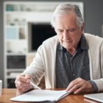 An older man reading over documents on healthcare planning