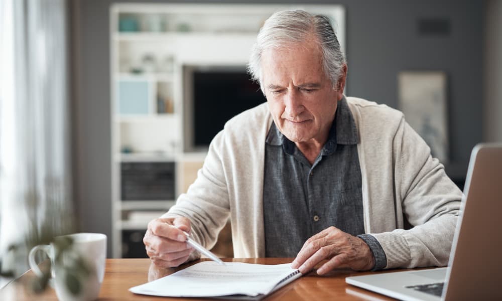 An older man reading over documents on healthcare planning