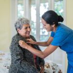 an older woman being cared for by a long-term care nurse