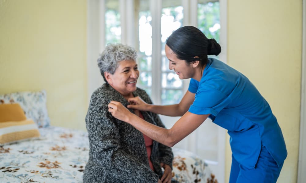 an older woman being cared for by a long-term care nurse