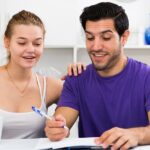 a couple sitting in their home discussing home insurance policy documents