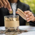 A man putting coins into a jar to save for retirement and college.