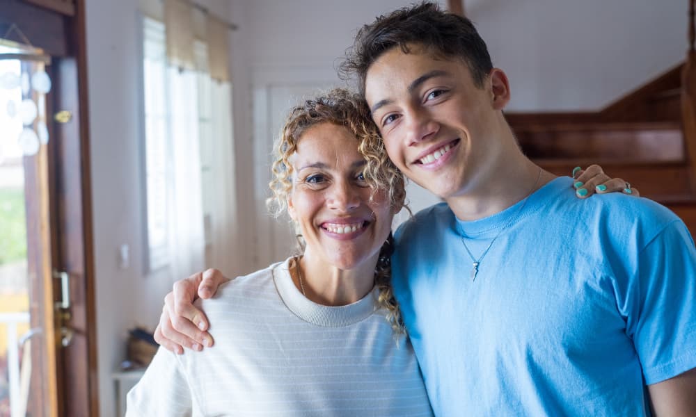 A single parent smiling with their child talking about college planning.