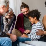 ee generations of a family meeting about education funding goals in a living room.