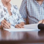 Elderly couple signing estate planning documents illustrating the importance of Will vs Trust decisions for families.