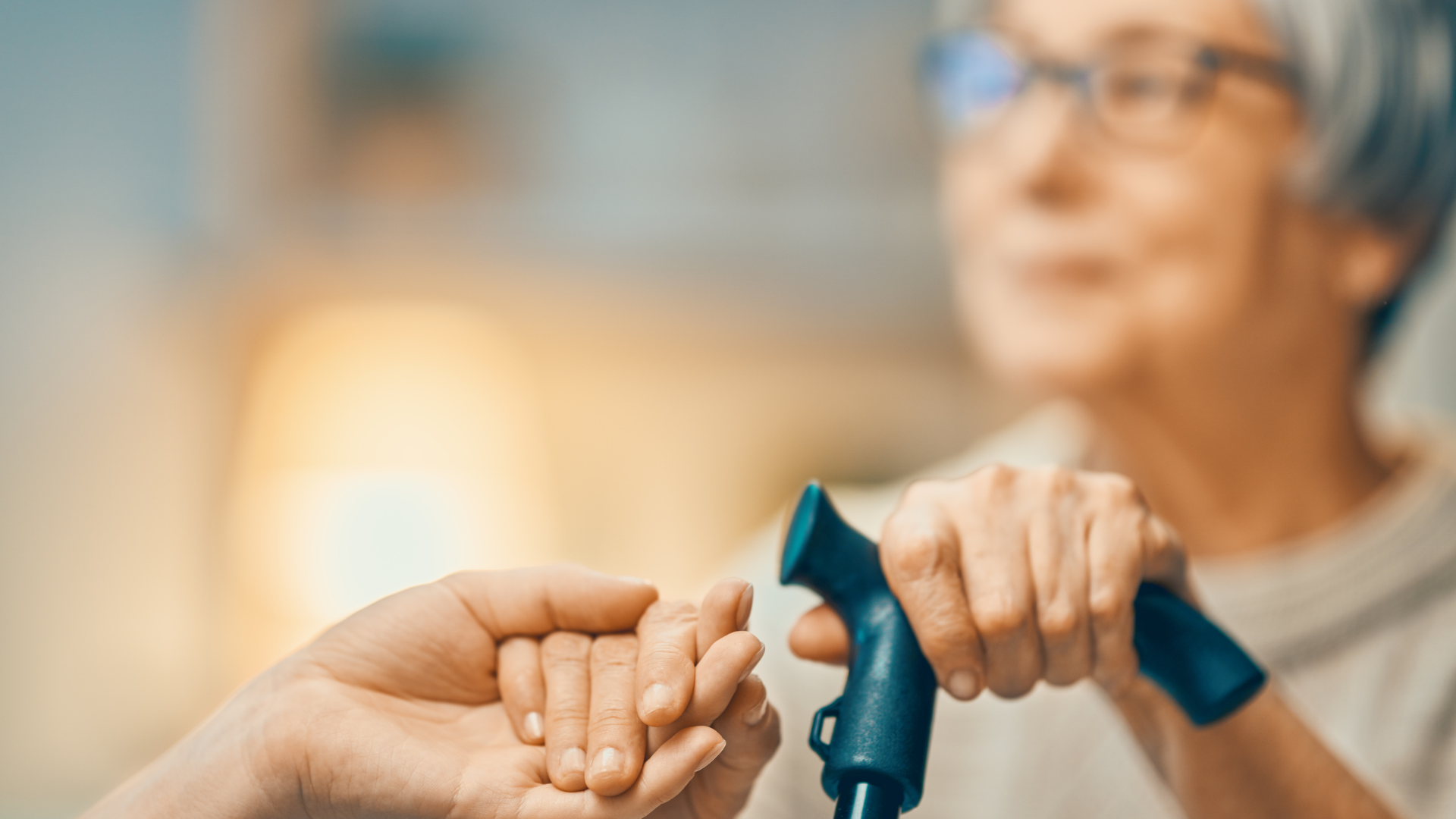 Elderly woman holding someone's hand, symbolizing Social Security benefits and retirement support.