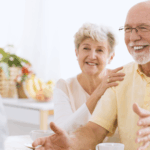 Elderly couple smiling and discussing financial planning strategies with their advisor about tax-loss harvesting before year-end.