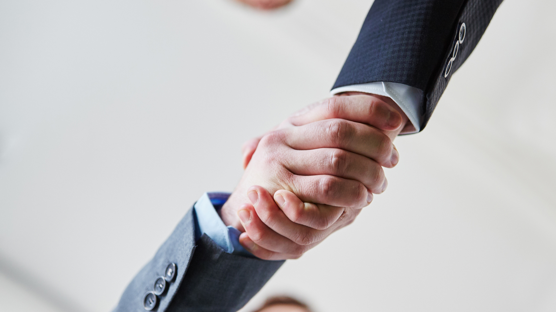 Close-up of two business professionals shaking hands, symbolizing partnership, trust, and successful business agreements.