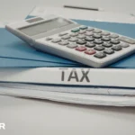 Calculator resting on tax documents, representing organized records to document your tax and prepare for filing