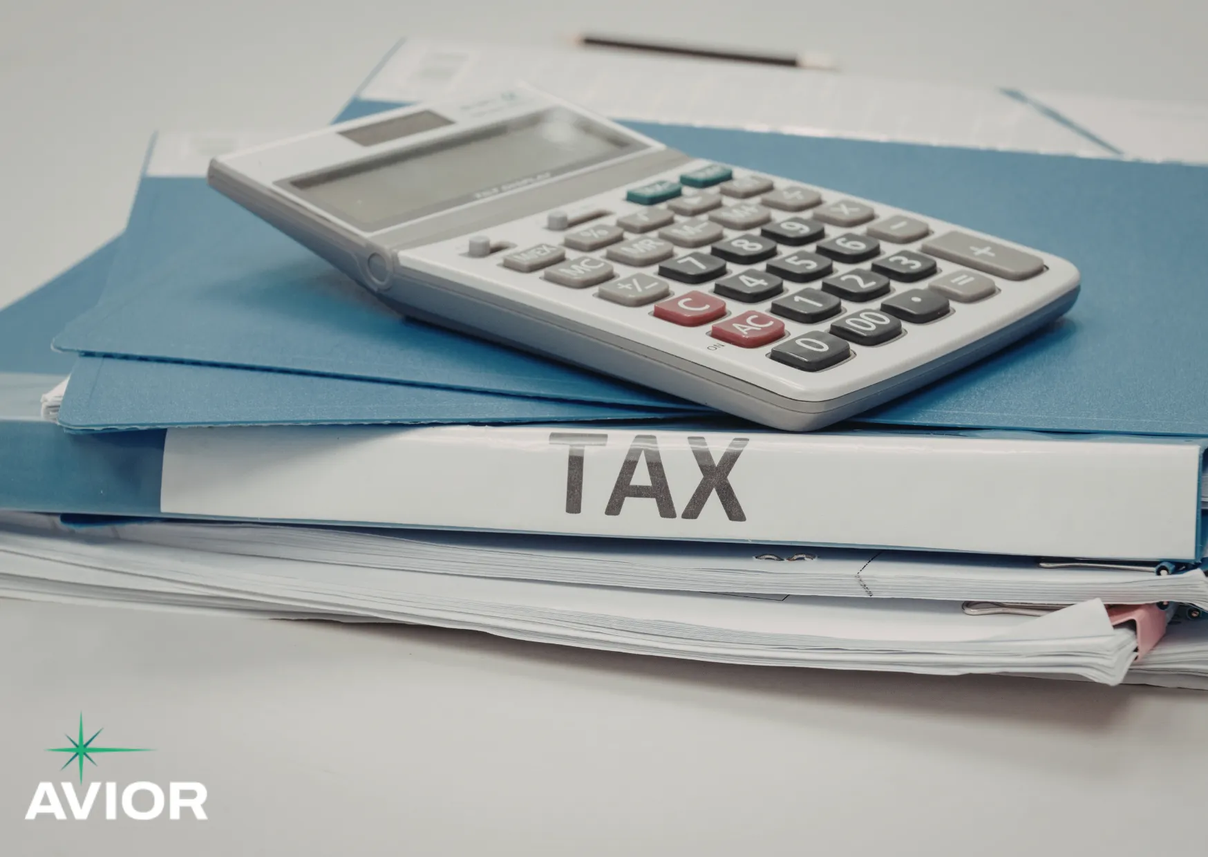 Calculator resting on tax documents, representing organized records to document your tax and prepare for filing
