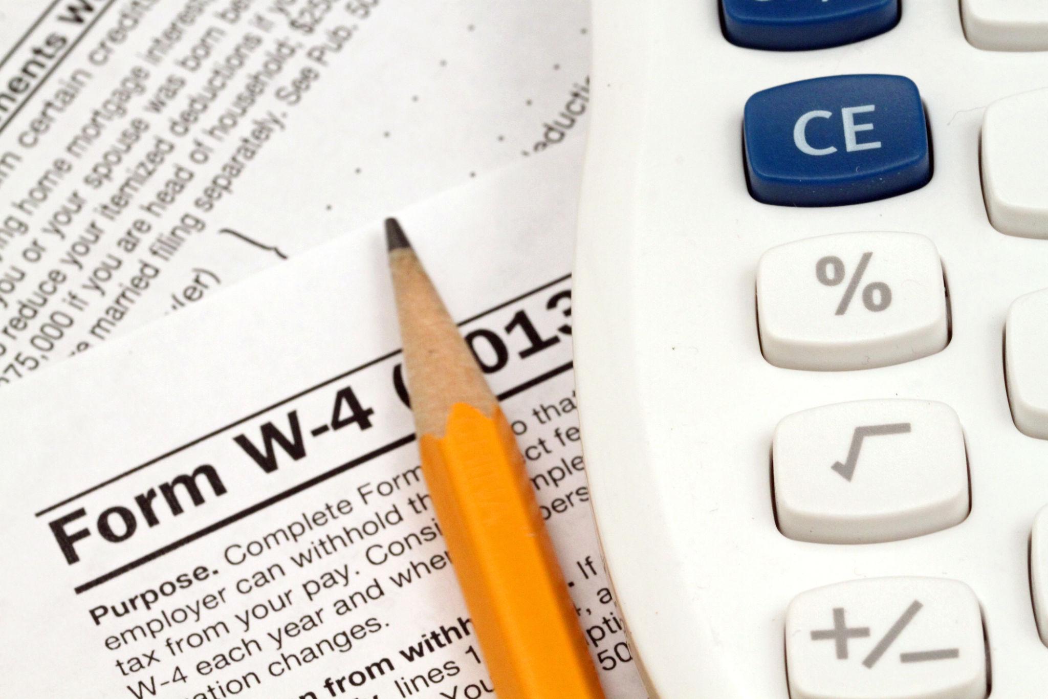 Financial advisor reviewing tax return and IRS Form W-4 to adjust withholding and plan post-filing tax strategy for 2026.