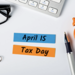 April 15 last minute tax day note with clock, pen, and office items on desk