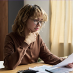 Woman reviewing financial documents and statements at desk during Q1 portfolio check and investment planning