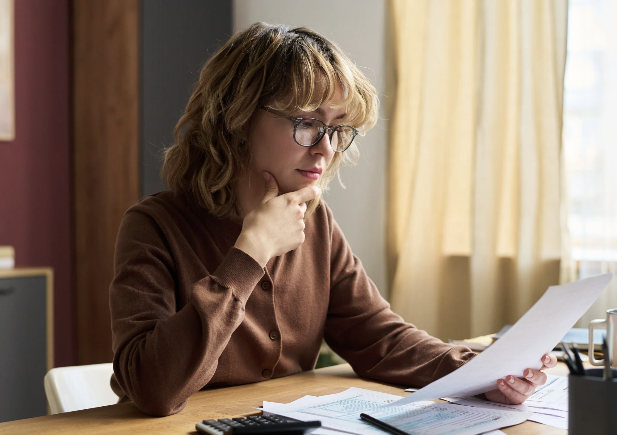 Woman reviewing financial documents and statements at desk during Q1 portfolio check and investment planning