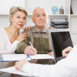 Older couple meeting with financial advisor to review estate planning documents and beneficiary decisions.