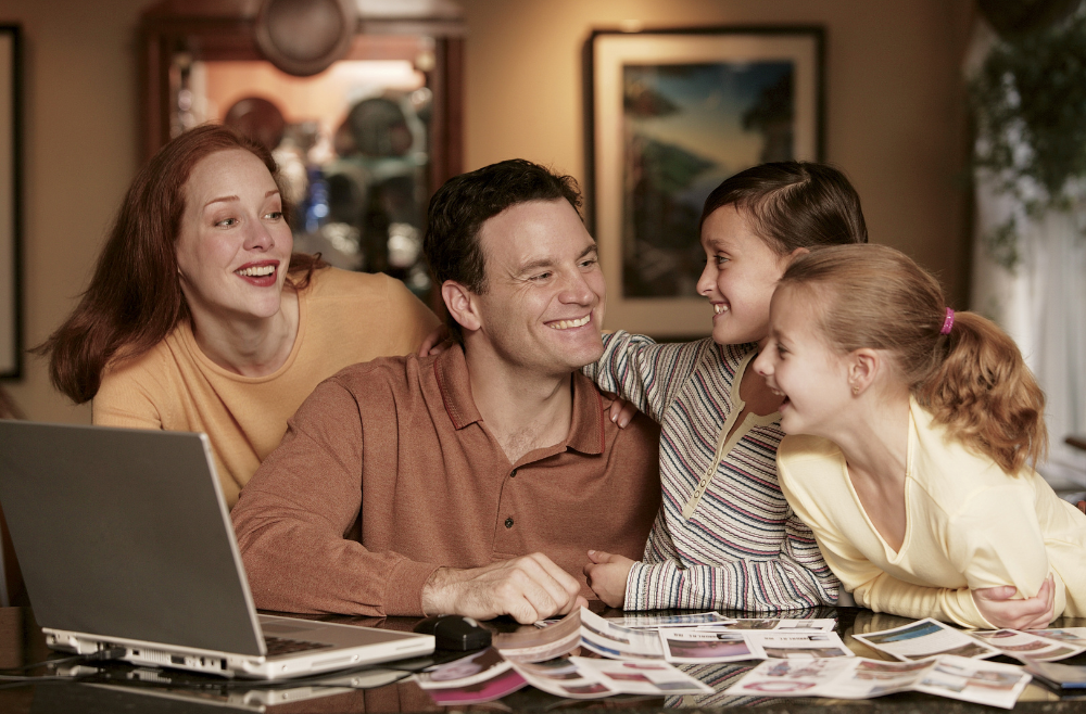 Family reviewing retirement income together with laptop and printed documents