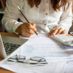 a woman with pencil and calculator on a form in the table