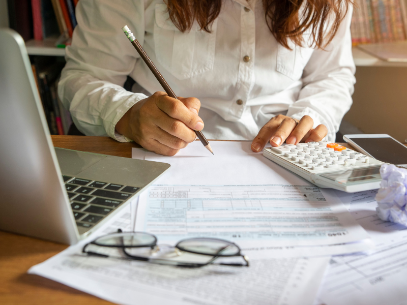 a woman with pencil and calculator on a form in the table